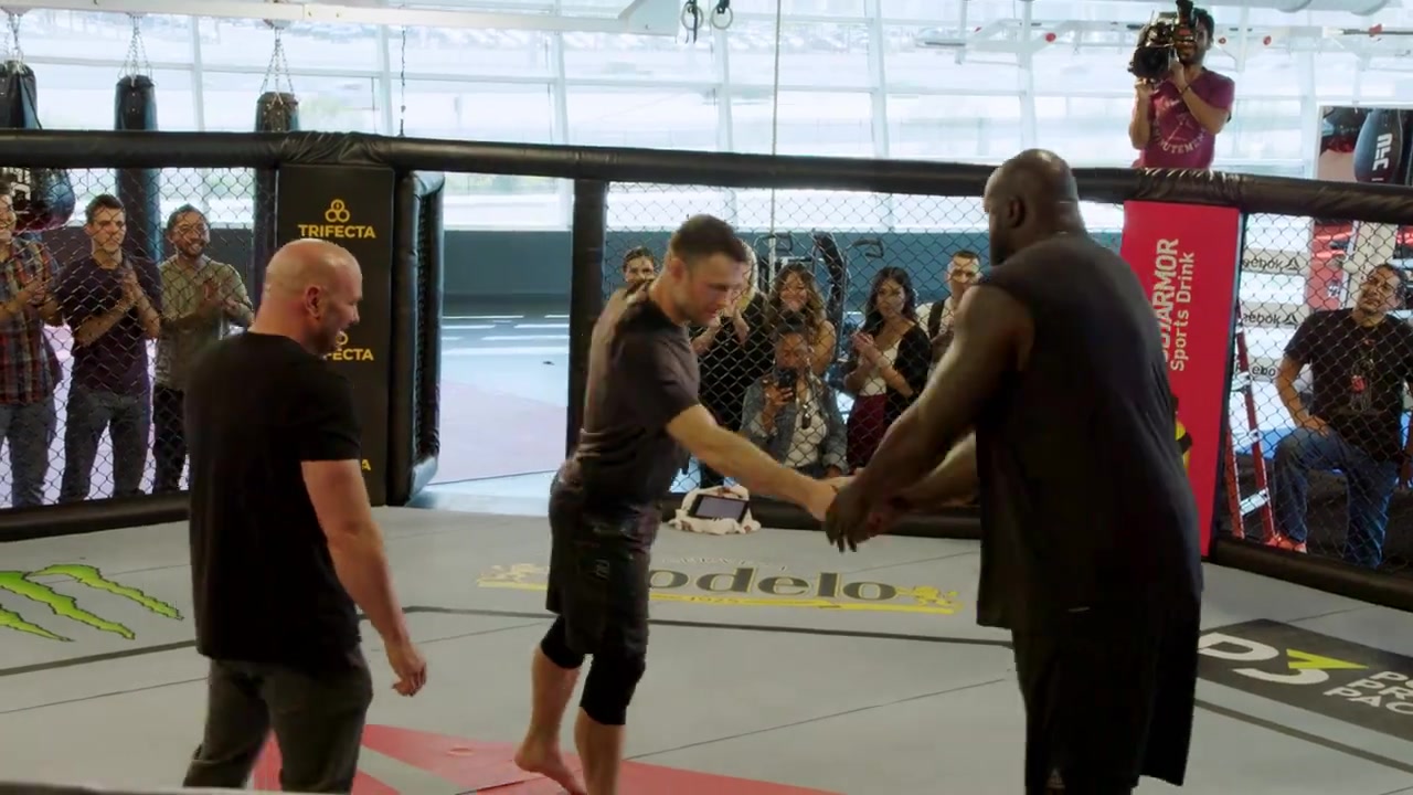 Shaquille O' Neal enters the cage with UFC fighters, Forrest Griffin and Claudinha Gadelha, as Dana White refs the fight