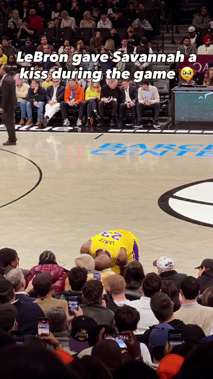 LeBron James kisses his teammates mother during the game