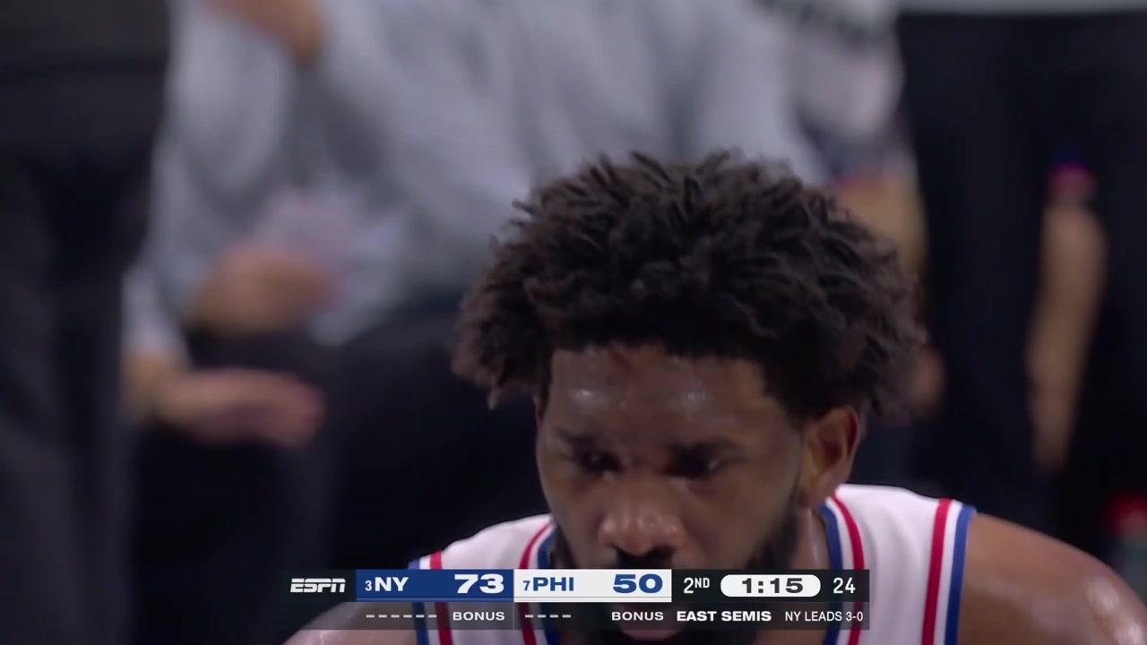 Knicks fans wave photos of Mitchell Robinson's poster dunk on Joel Embiid behind the basket during Embiid's free throwsIt didn't affect Joel