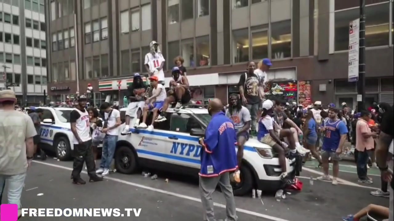 Knicks fans climbing police vehicles to get a better view of the parade