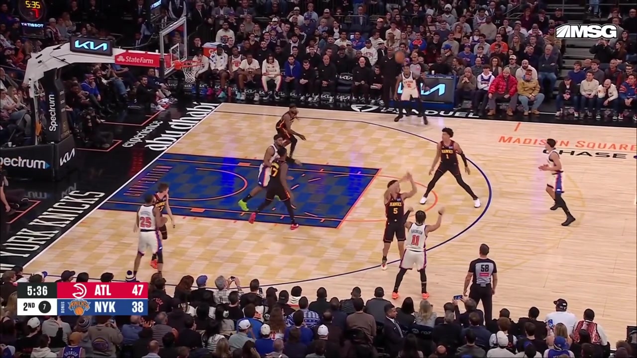 Miles McBride skies to catch Brunson's pass and contorts for the clean swish over NAW