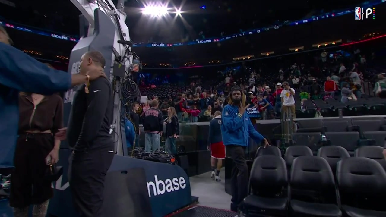 Joel Embiid gives away his a jersey to a fan after the Clippers game takes a photo with him and having conversation with him