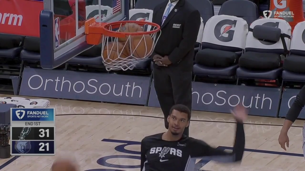 Wemby high kicks a bunch of basketballs stuck in the hoop