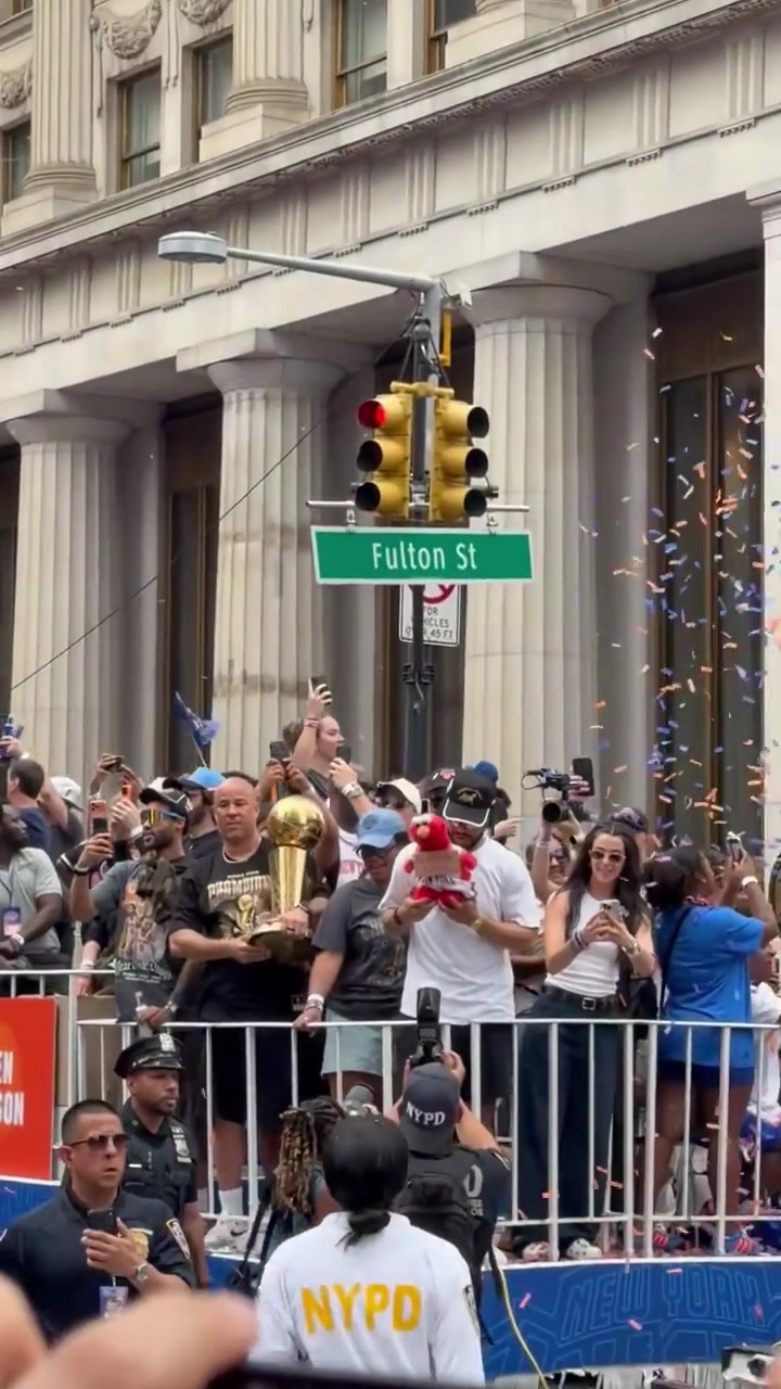 Jalen Brunson holds up an Elmo plushie during the parade with Elmo wearing a sign reading Forgive me PLEASE
