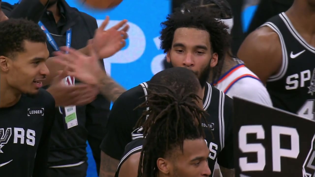 Julian Champagnie is grabbed from his jersey taken by BIsmack Biyombo to do the new Spurs tradition with the drum after scoring a career-high 11 threes setting also a franchise record