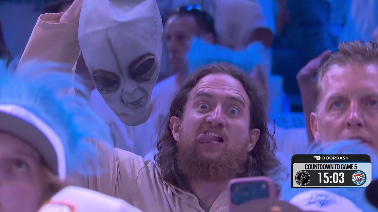 A fan in Oklahoma makes a weird expression while holding an alien mask