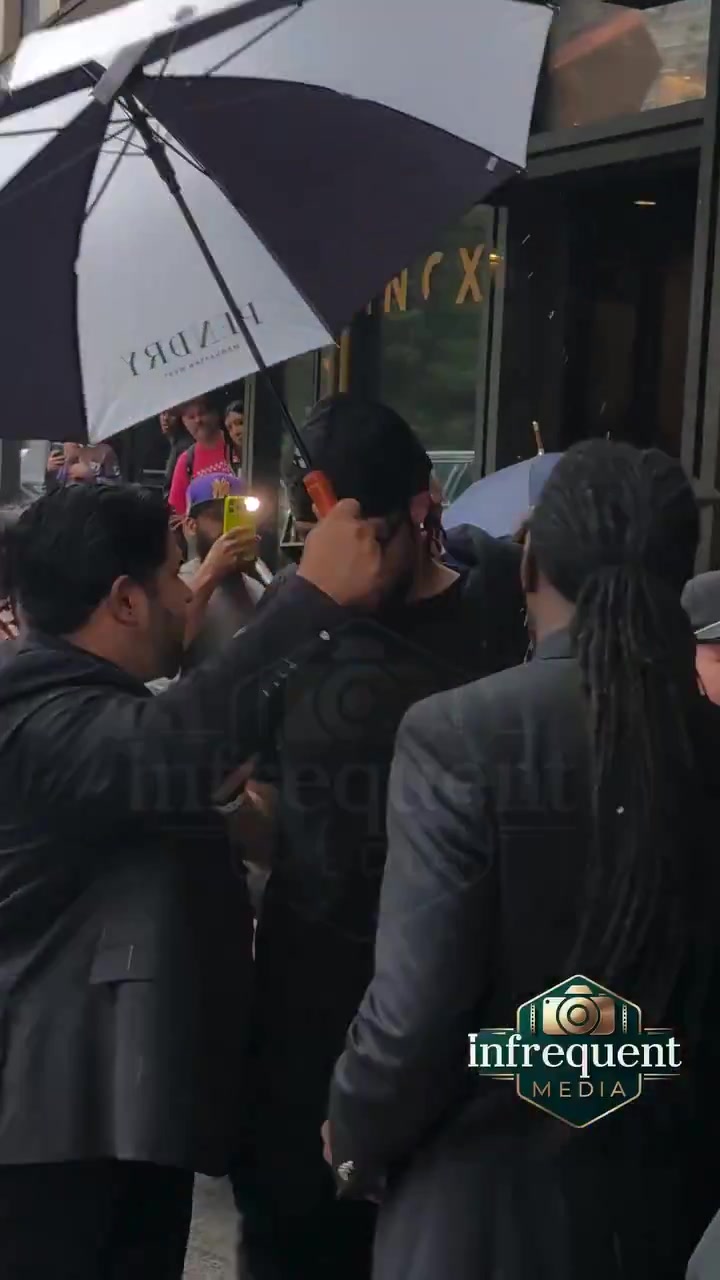 New Yorker uses his personal umbrella to protect Jalen Brunson from the rain
